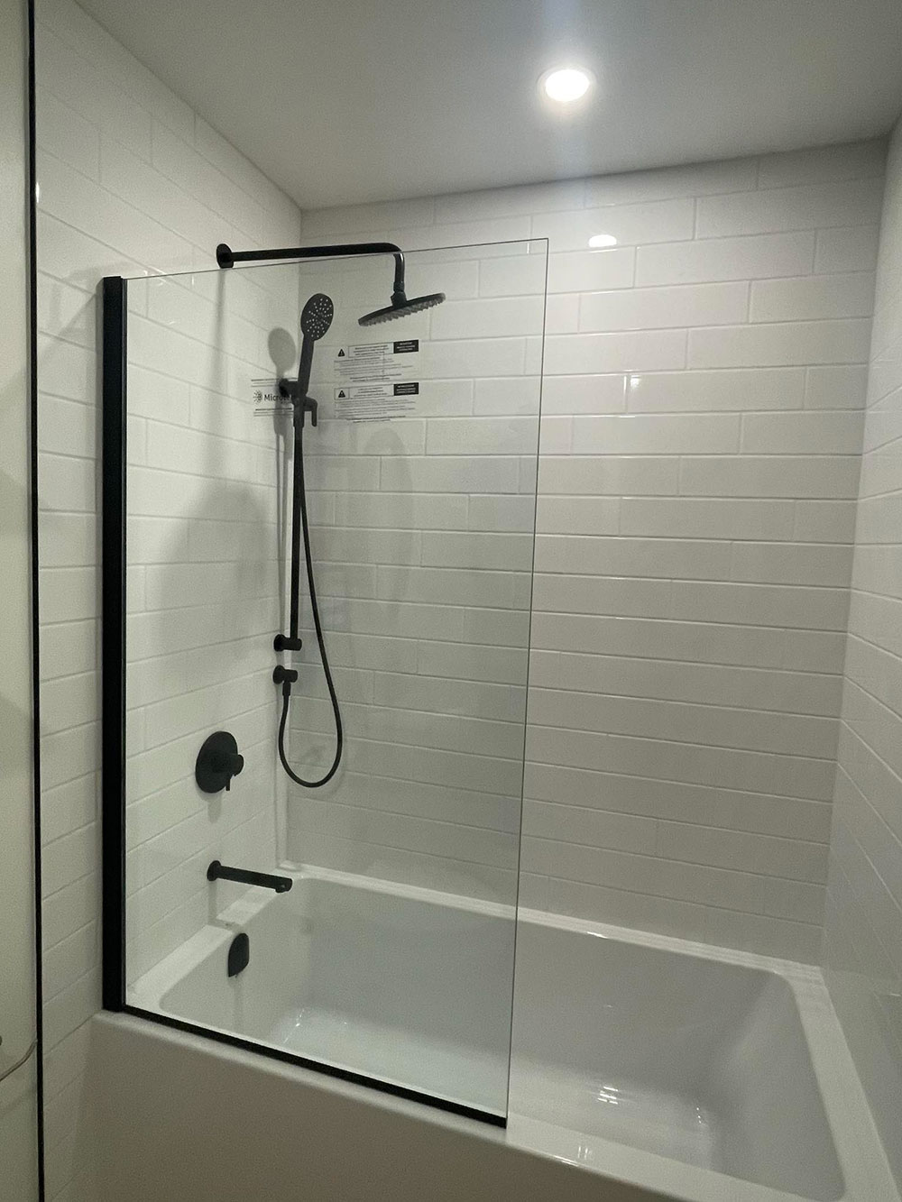 black shower faucet with handheld and bath tub
