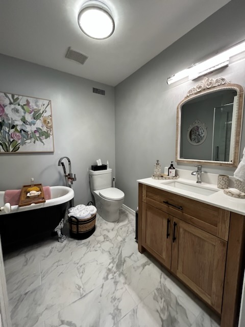 renovated bathroom with bath tub, toilet and lavatory